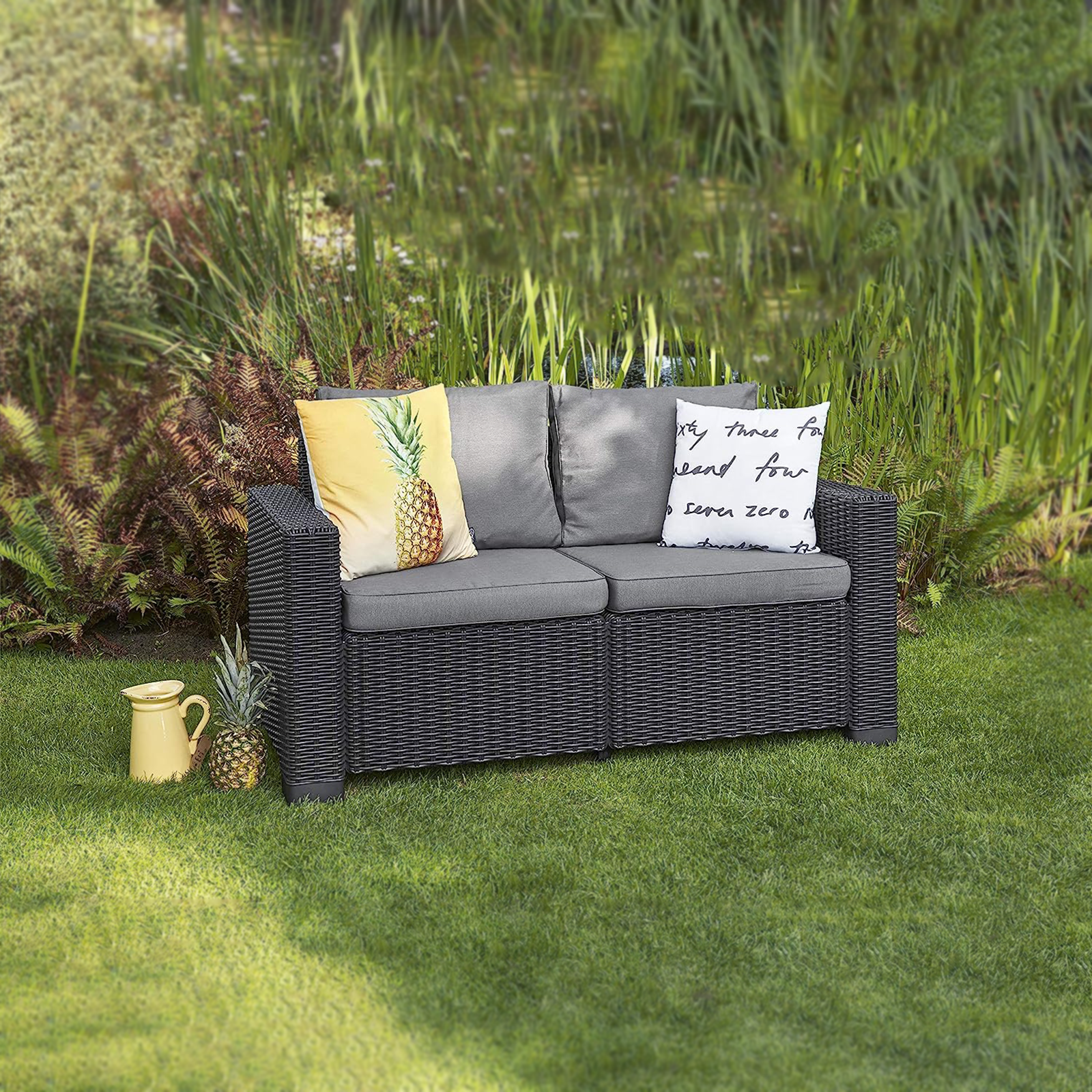 "California" 2-seater rattan-effect resin sofa with cushions, 141 x 68 cm, 72 cm high.